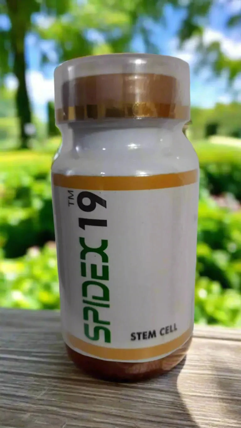 Bottle of Spidex 19 stem cell supplement on wooden surface with green outdoor background